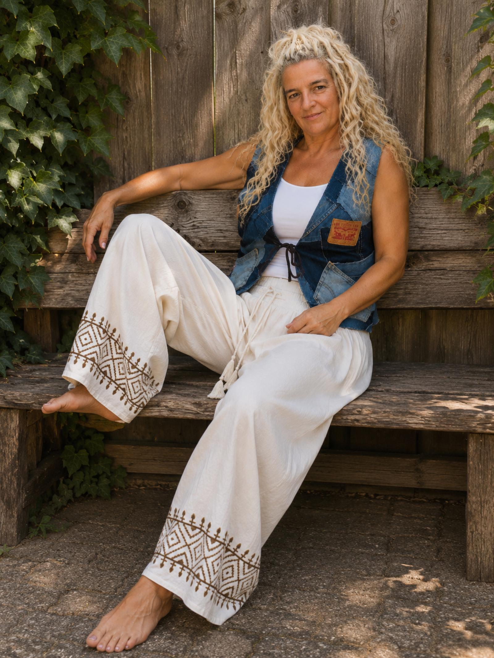 Zittende sfeerfoto van luchtige boho broek van katoen.