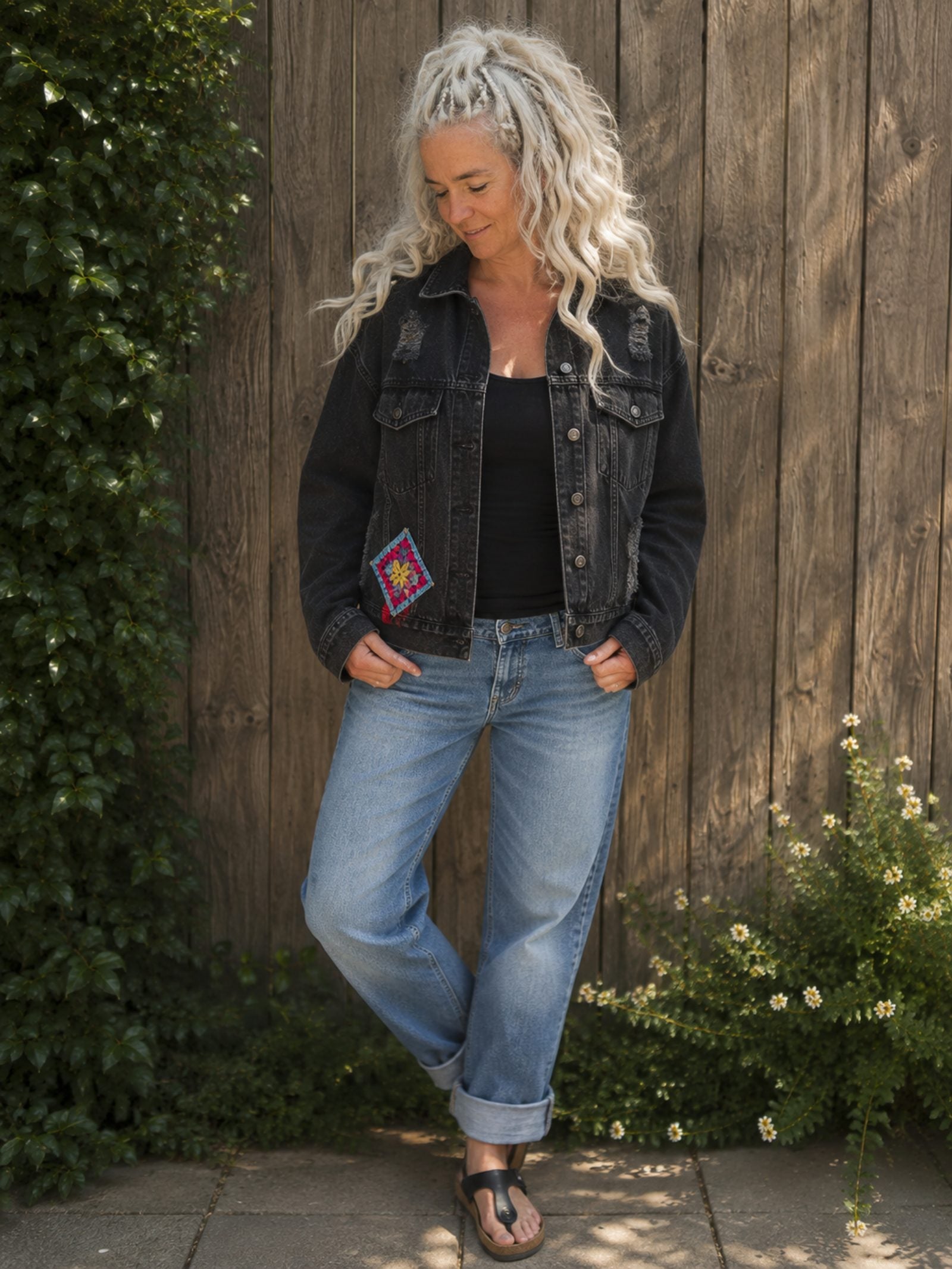 One of a Kind zwart denim jasje met gehaakte granny square op de voorkant gedragen door model.
