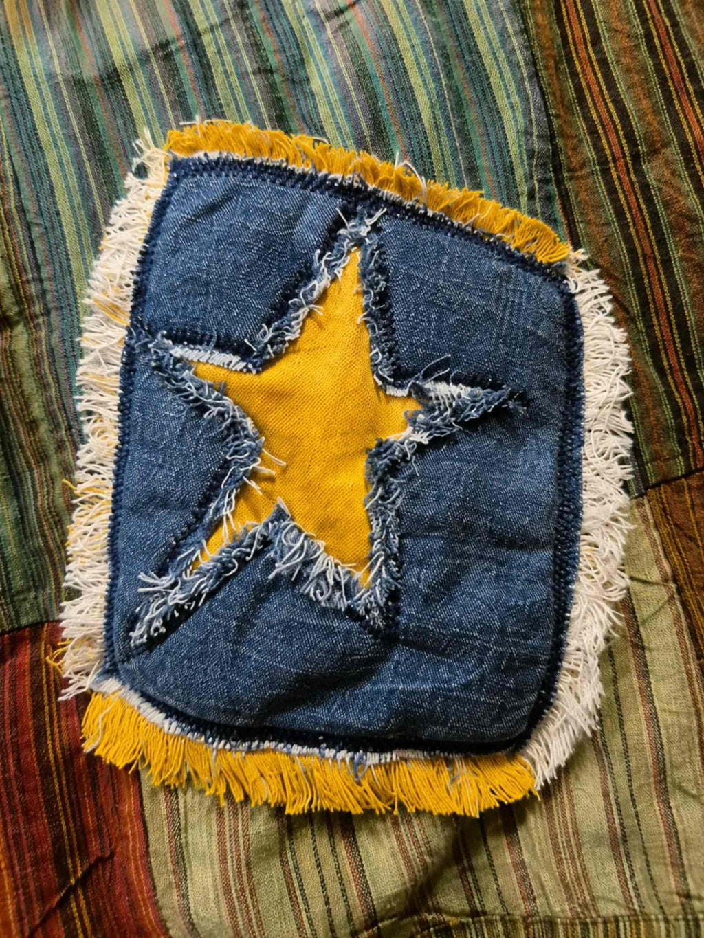 Detailfoto van een handgemaakte sterpatch op een One of a Kind boho hesje van Old New Atelier