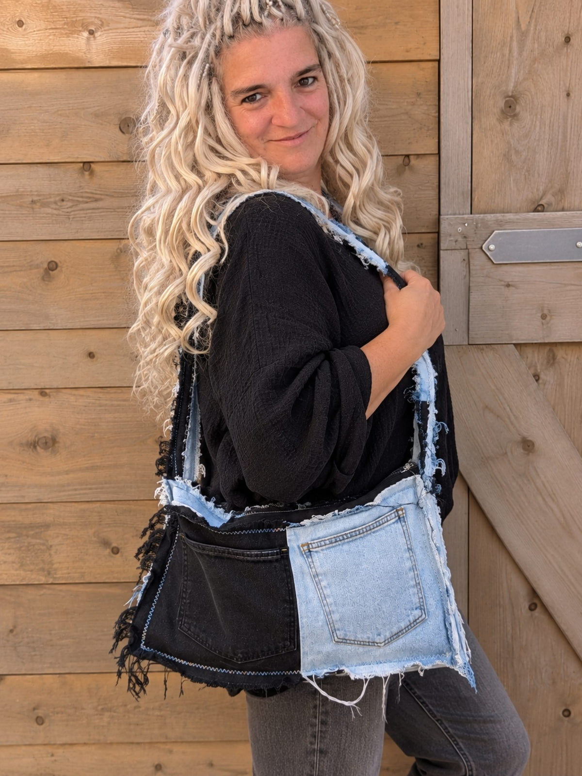 Upcycled denim patchwork tas gedragen in 3/4 zijaanzicht
