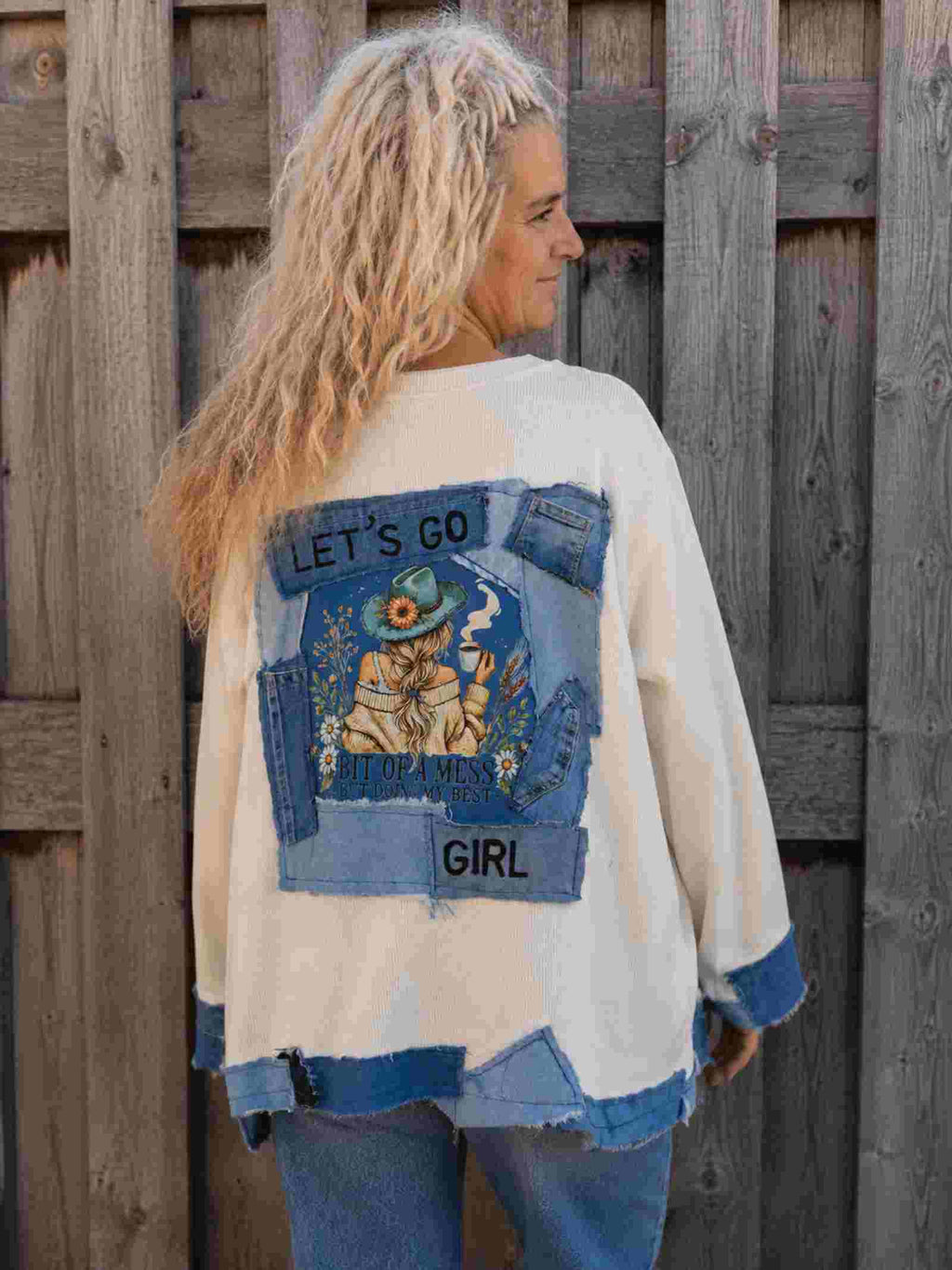 Handgemaakte Let's Go Girl top van Old New Atelier met denim applicaties en illustratie op de rug, gedragen door model.