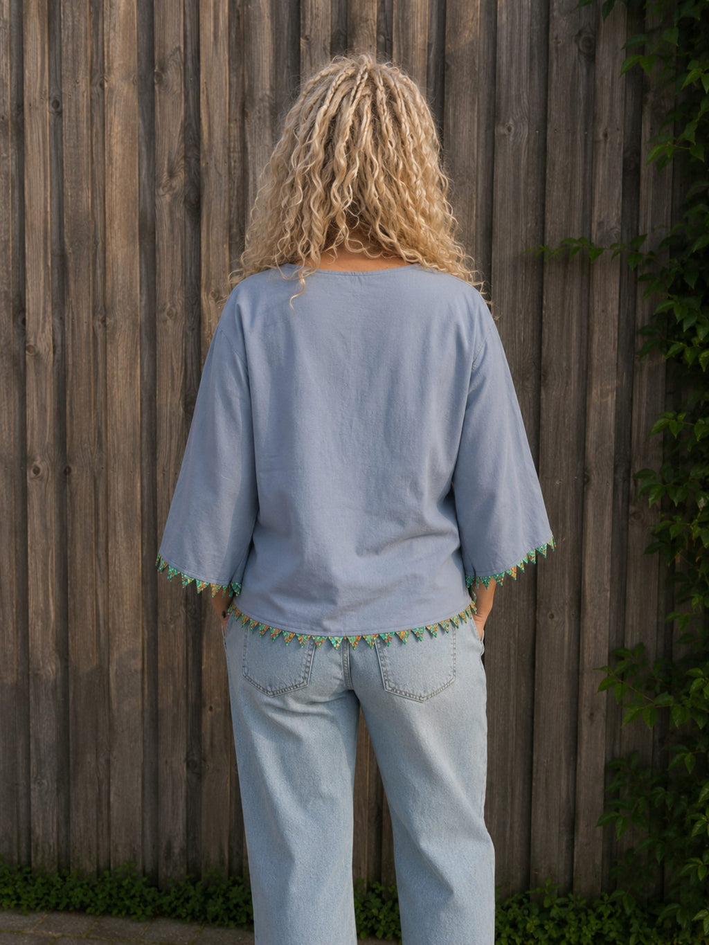 Achterkant van handgemaakte lichtblauwe boho blouse met kralendetails – Old New Atelier