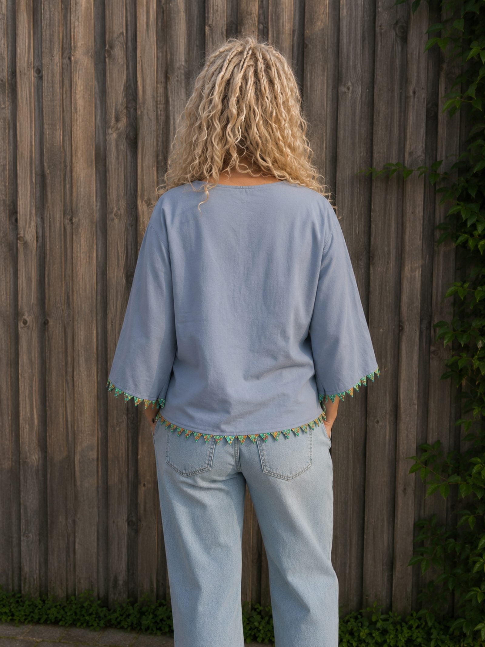 Achterkant van handgemaakte lichtblauwe boho blouse met kralendetails – Old New Atelier
