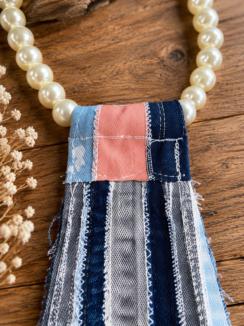 Detail van parelketting met blauw roze patchwork denim van handgemaakte tie necklace