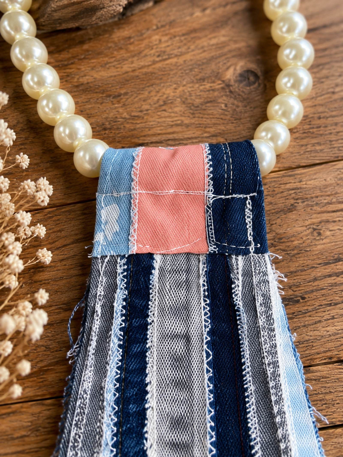 Detail van parelketting met blauw roze patchwork denim van handgemaakte tie necklace