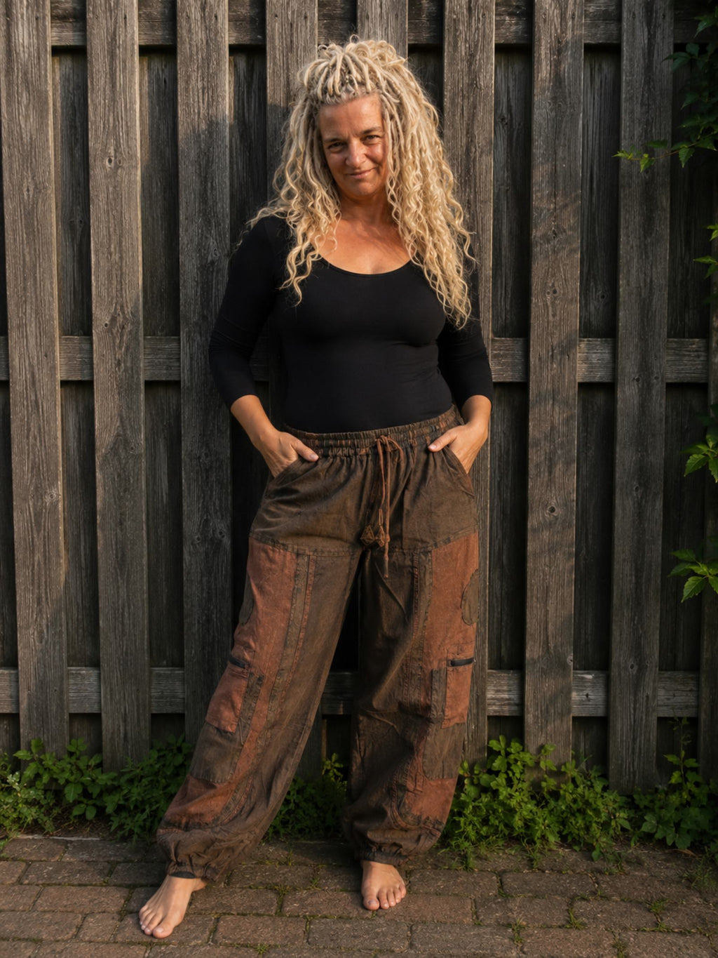 Boho baggy broek voor dames in bruin en roestkleur met patchwork print en elastische taille, gedragen door model – Old New Atelier