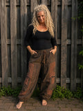 Boho baggy broek voor dames in bruin en roestkleur met patchwork print en elastische taille, gedragen door model – Old New Atelier
