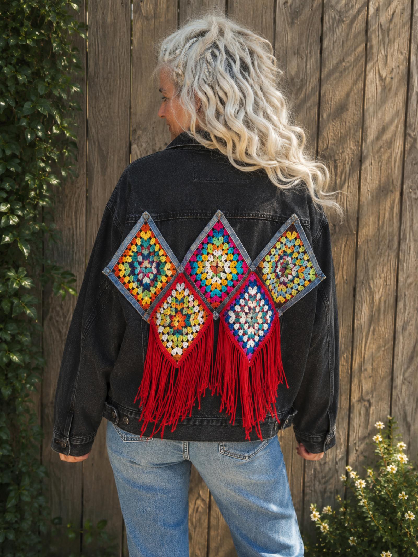 One of a Kind zwart denim jasje met gehaakt rugkunstwerk en rode franjes gedragen door model.