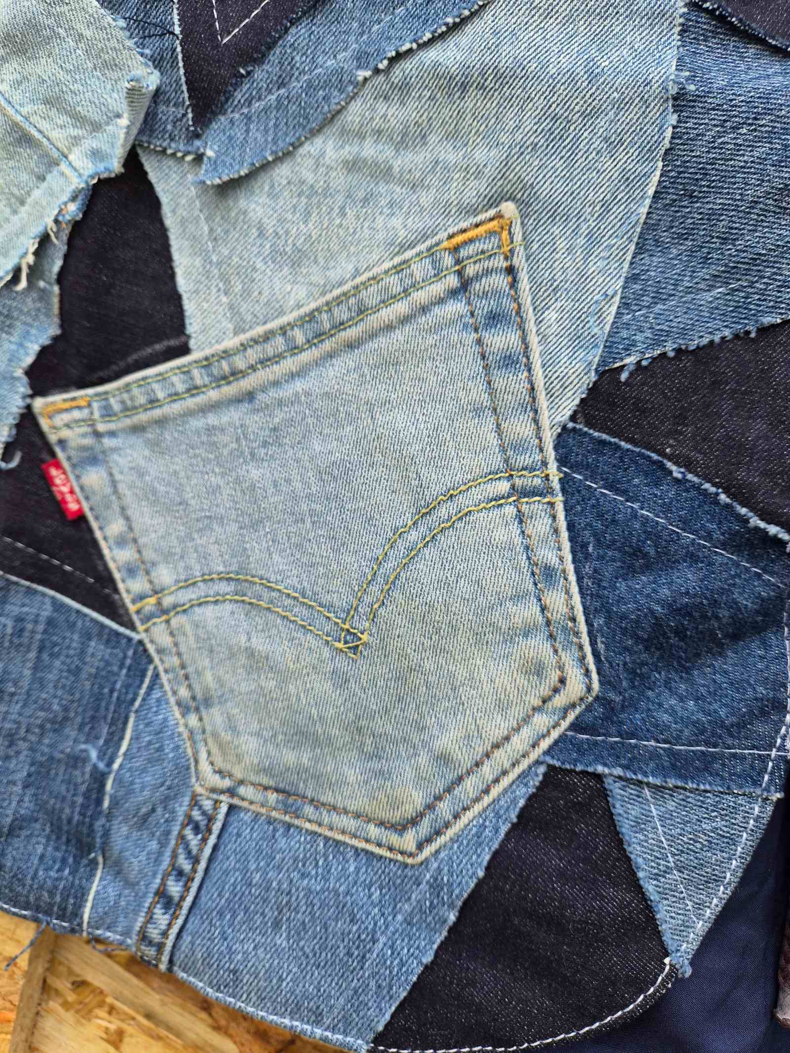 Detail van origineel Levi's label en gerecyclede jeanszak op een handgemaakt upcycled denim hesje.