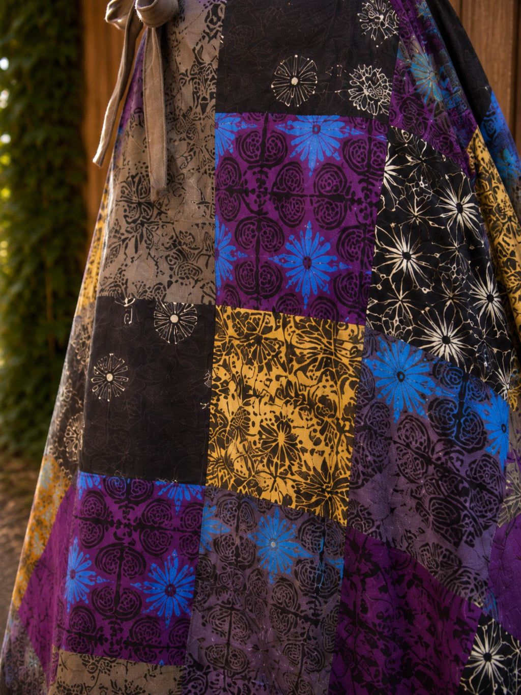 Close-up van handgemaakt patchwork op paarse katoenen wrap rok