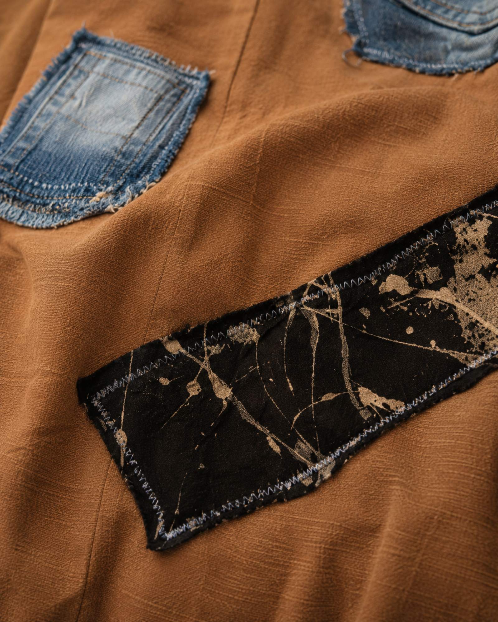 Close-up van handgemaakte denim patches en stofdetails op een one of a kind boho top van Old New Atelier.