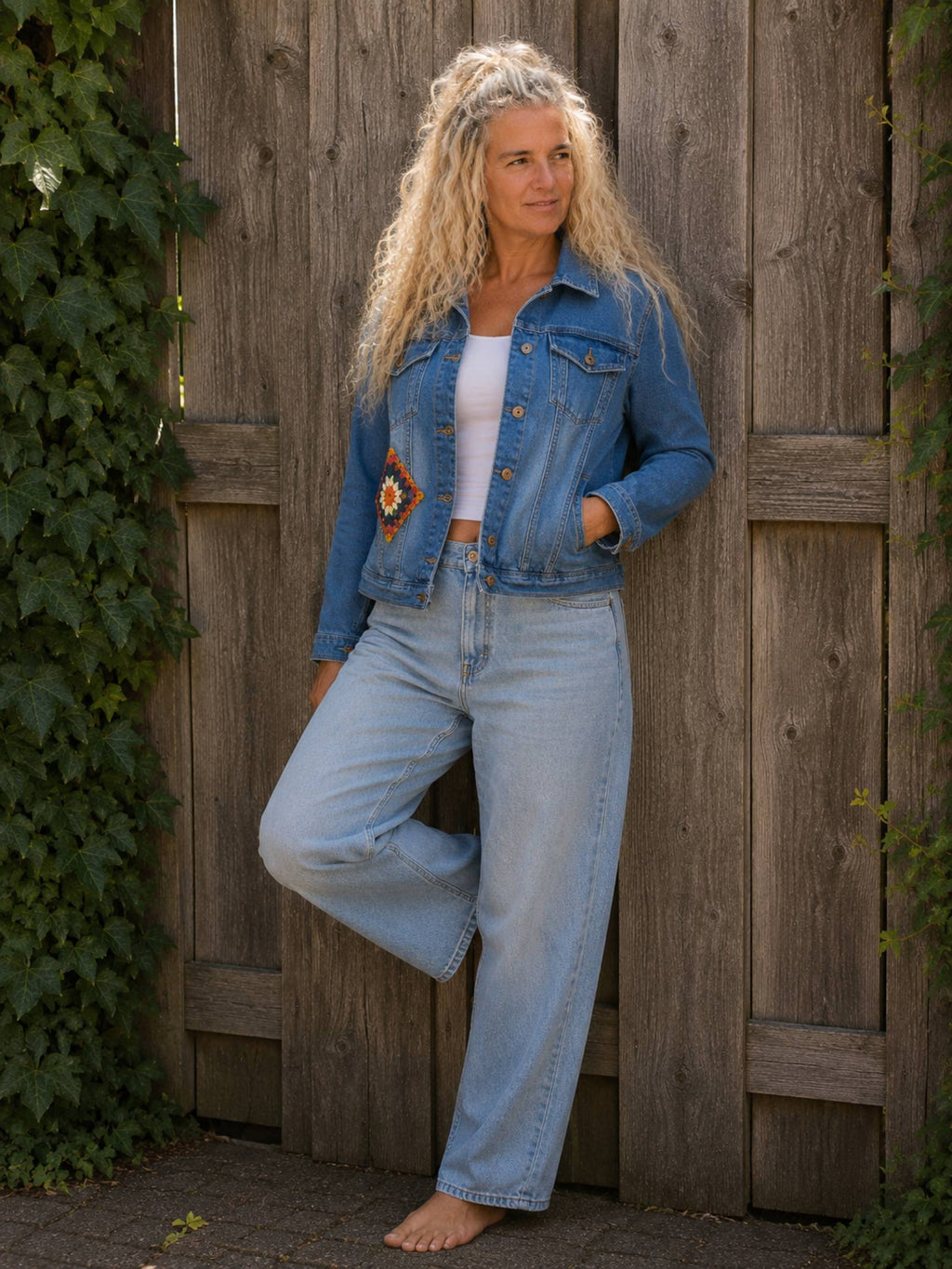 One of a Kind upcycled denim jasje met gehaakte voorpatch, handgemaakt boho jasje gedragen door model.