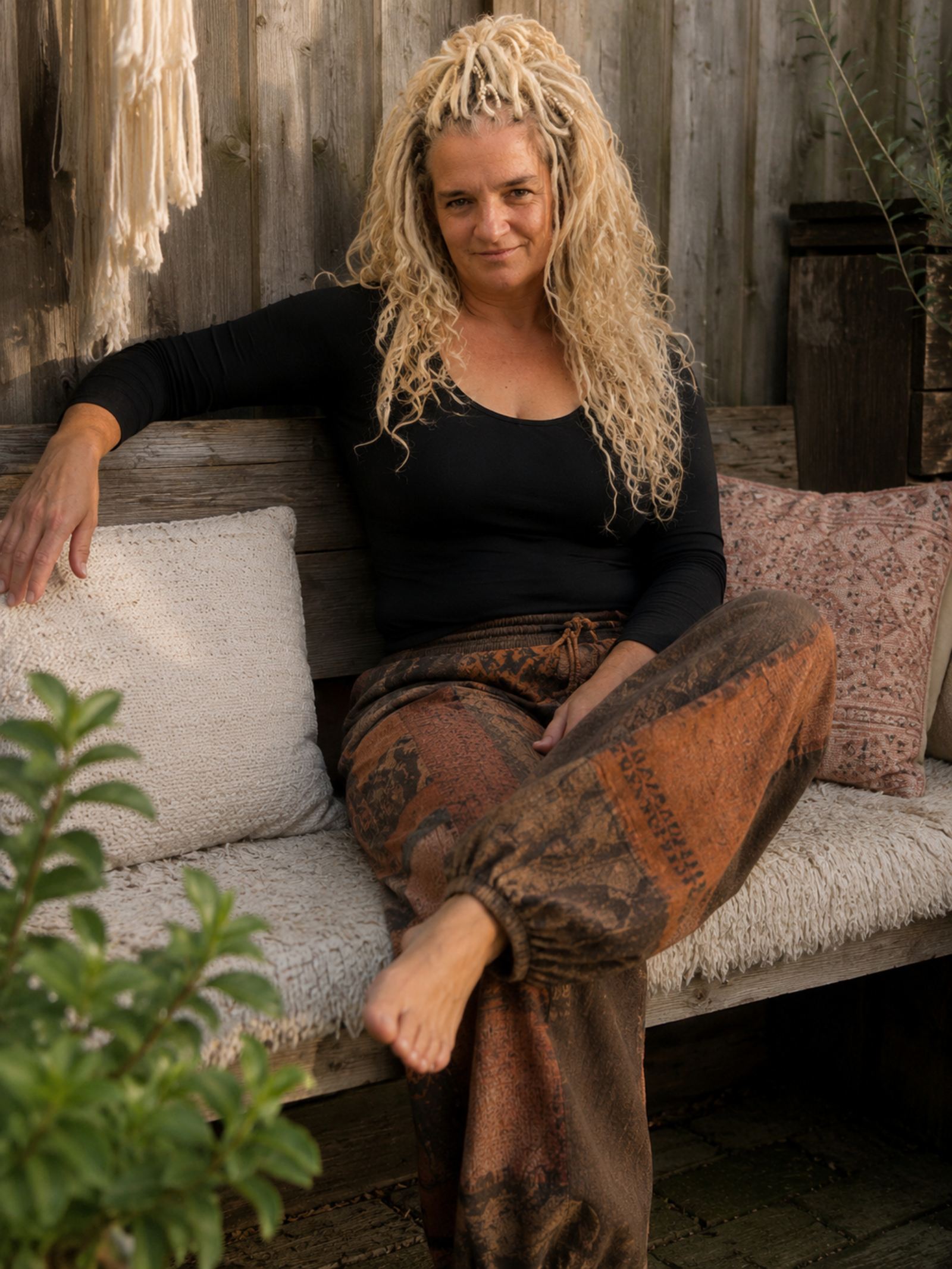 Boho baggy broek in ontspannen boho stijl gedragen op een houten bankje – Old New Atelier