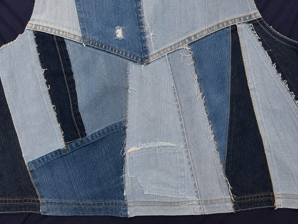 Close-up van het unieke denim patchwork op de achterzijde van Blue Nomad L/XL Levi's patchwork hesje.