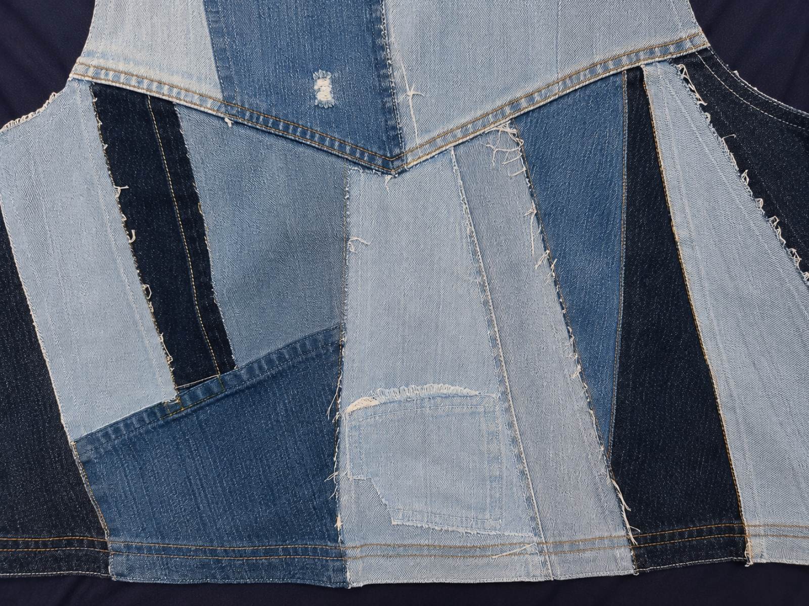 Close-up van het unieke denim patchwork op de achterzijde van Blue Nomad L/XL Levi's patchwork hesje.