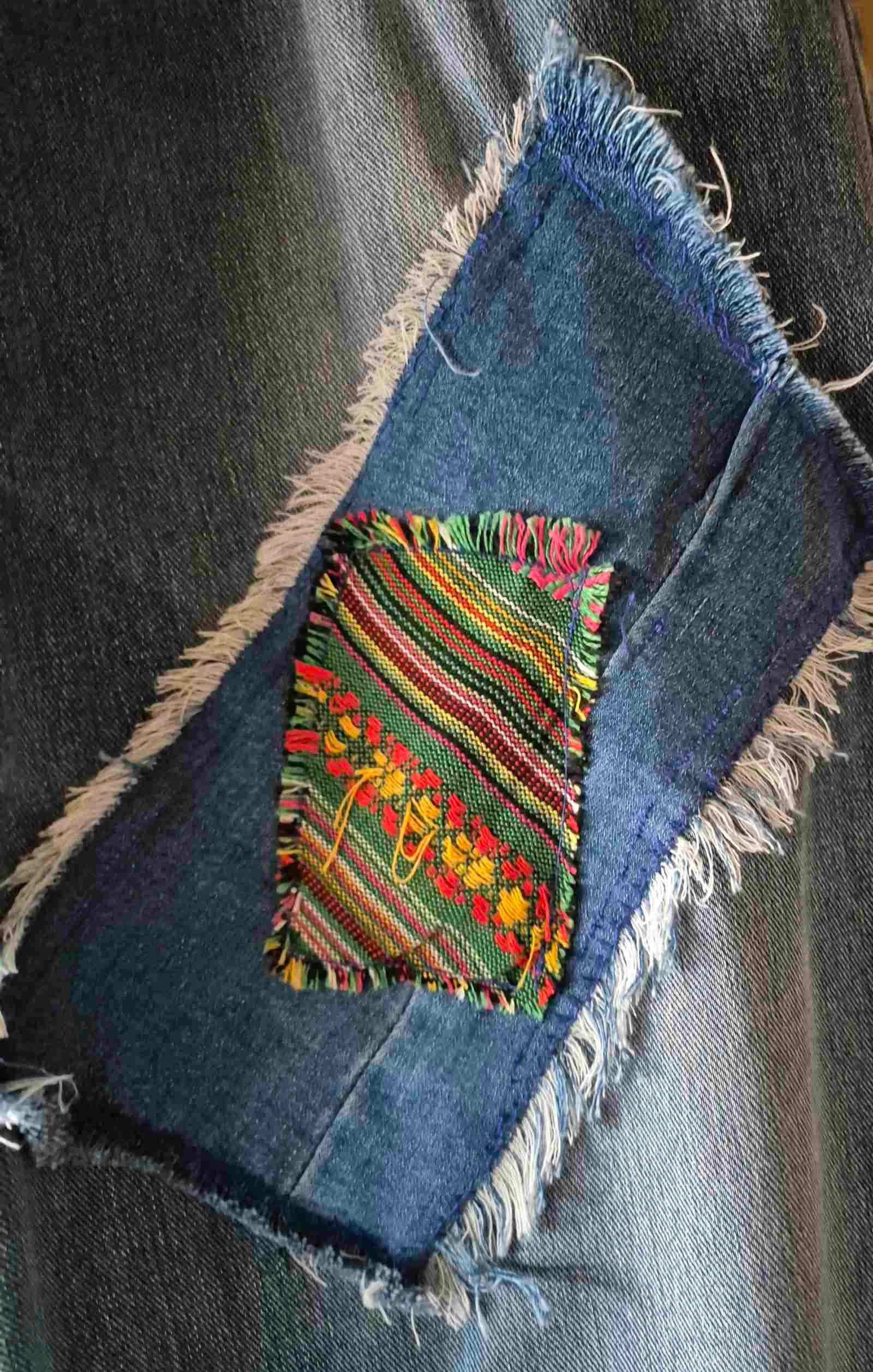 Close-up kleurrijke textiel en denim patchwork applicatie op Hippie Spirit jeans
