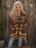 Vrouwelijk model draagt een oversized boho poncho met capuchon, franjes en Buddha details van Old New Atelier.