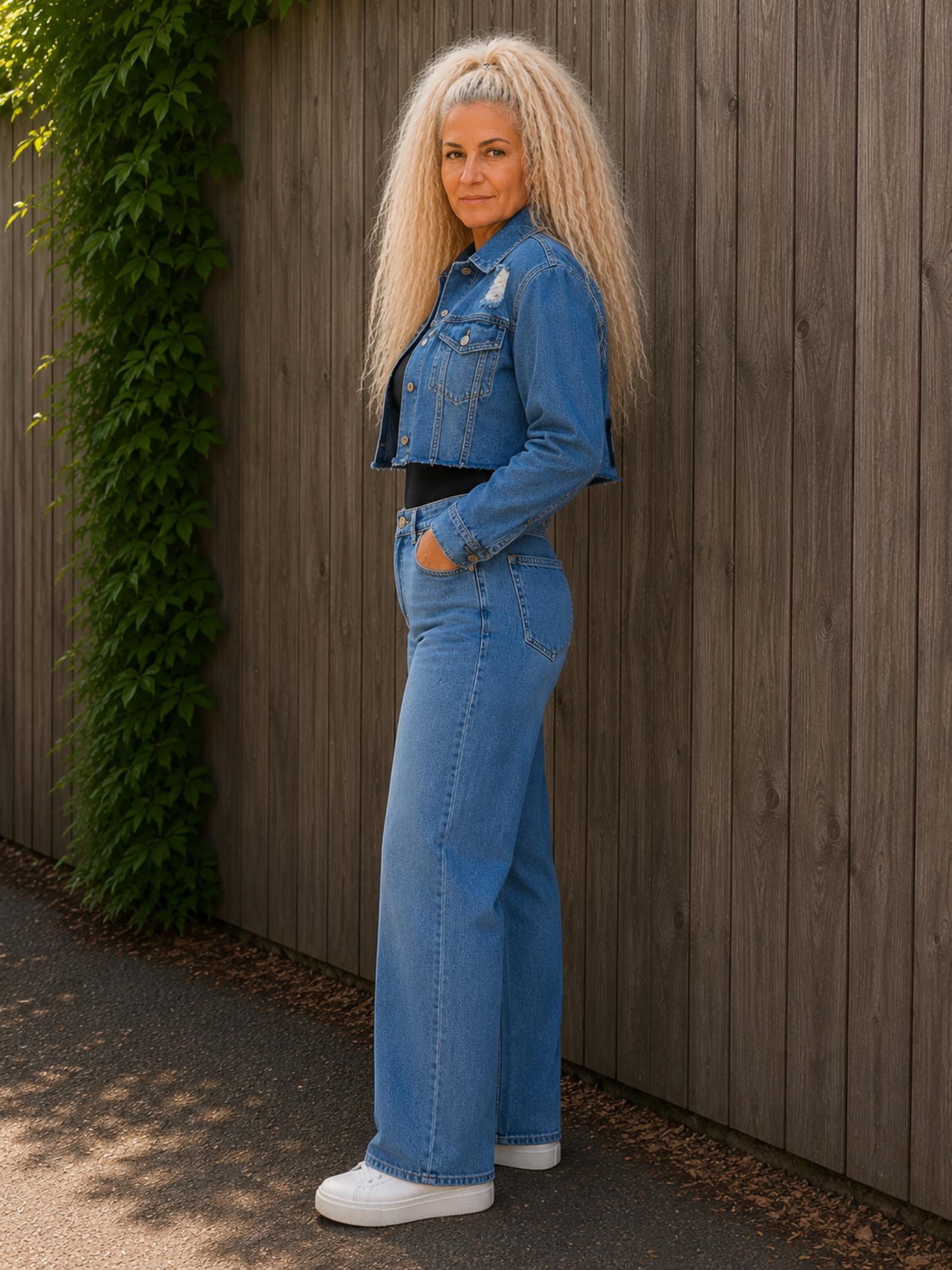 Zijaanzicht van een One of a Kind upcycled denim crop jasje gedragen door model met cropped pasvorm en vintage denim uitstraling