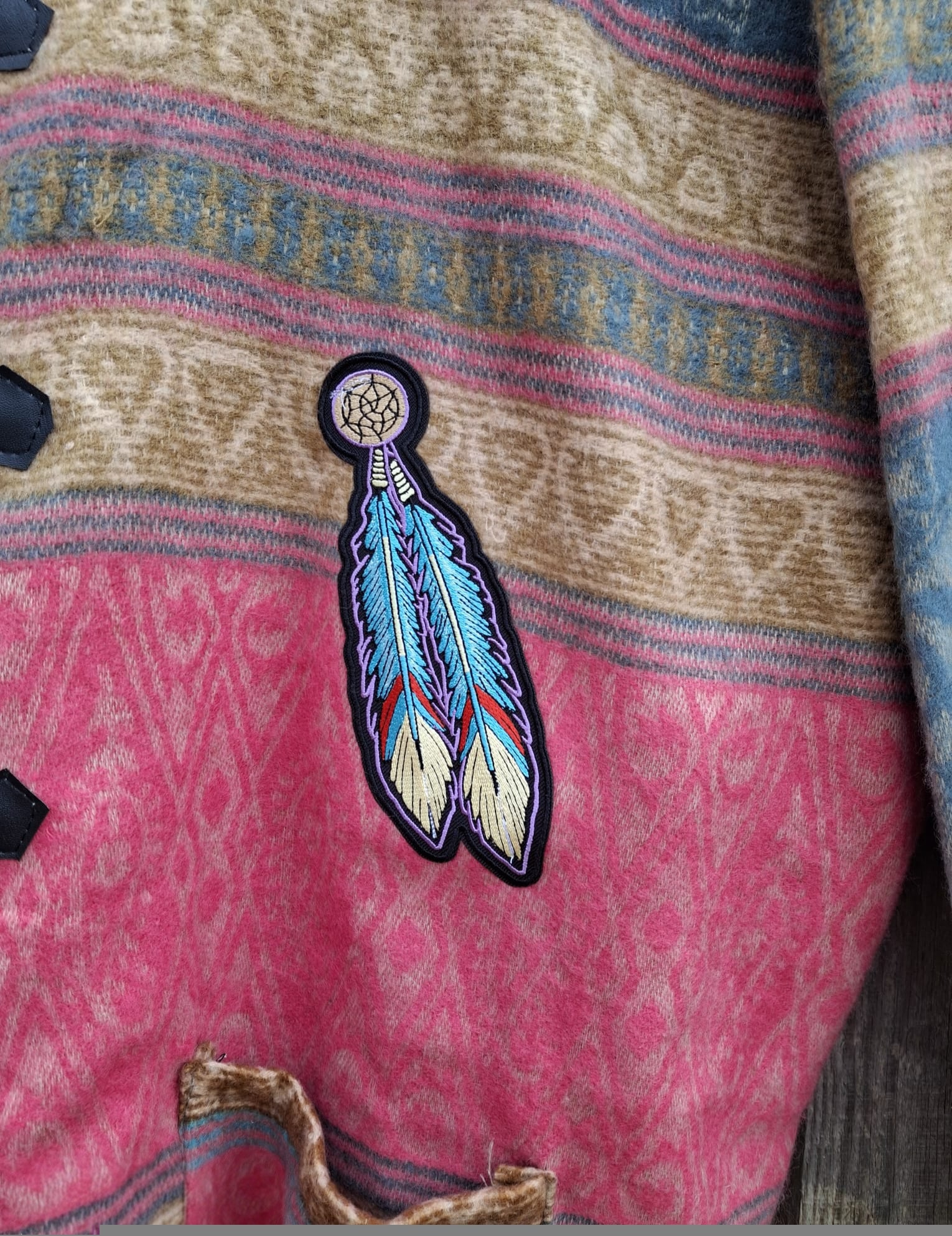 “Close-up van kleurrijke feather dreamcatcher patch op handgemaakt boho hoodie vest