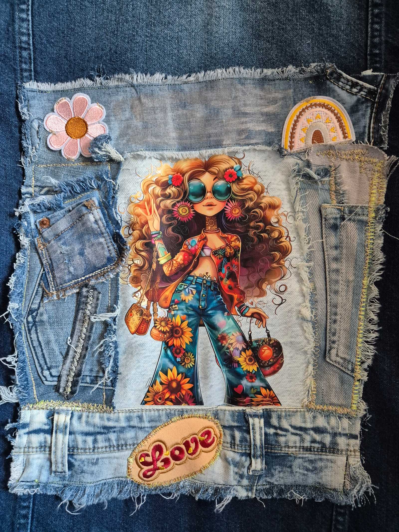Detail of upcycled denim jacket with artistic boho print and denim patches