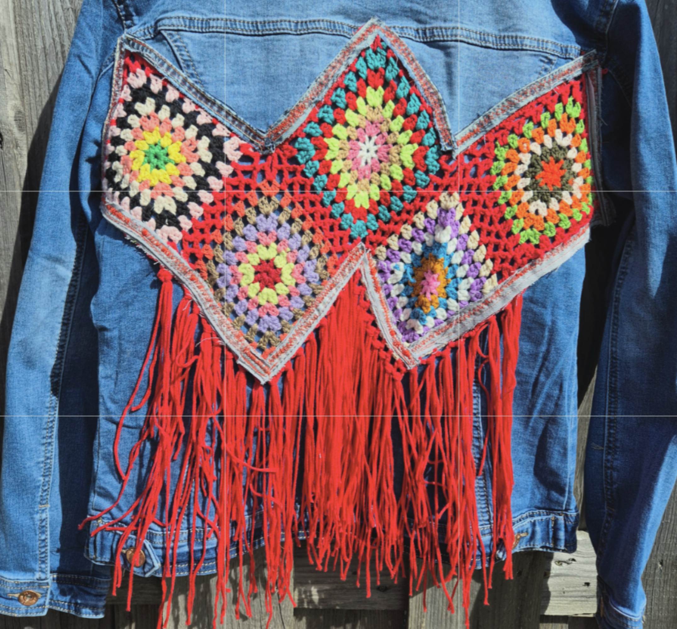 Detail van upcycled denim jasje met handgemaakte crochet patchwork en rode franjes – boho stijl
