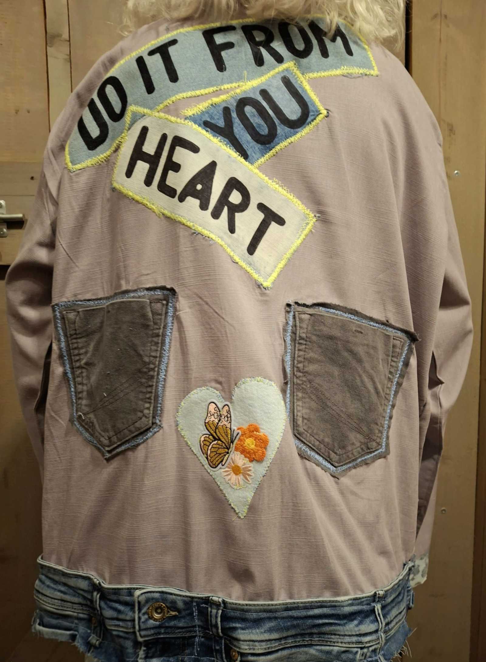 Achterkant upcycled jasje met handgemaakte tekst en denim zakken